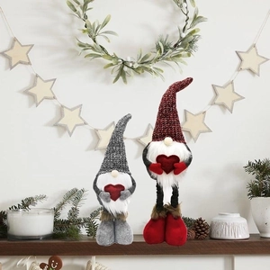 Detailed plush Christmas gnomes with red hearts on a festive wooden mantle setup