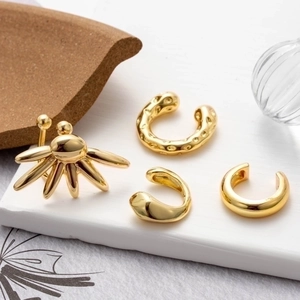 Set of four gold non-piercing ear cuffs with textured and minimalist floral designs
