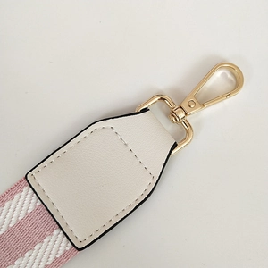 Detail of pink and white striped bag strap with white leather and gold metal buckle
