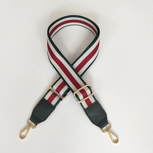 Adjustable woven shoulder strap with red, green, and white stripes and gold buckles