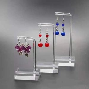 Three-piece clear acrylic earring display stands in a tiered layout for jewelry storage