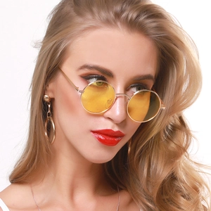 Retro round metal sunglasses with yellow transparent lenses worn by a fashion model
