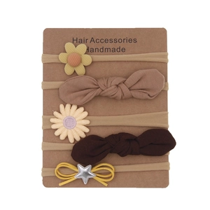 Detail of 5-piece floral baby headbands set in earth tones on handmade card packaging