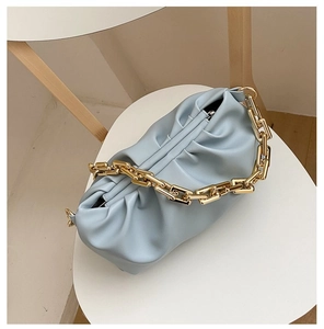 Detail of light blue cloud bag with soft pleats and chunky gold metal chain strap