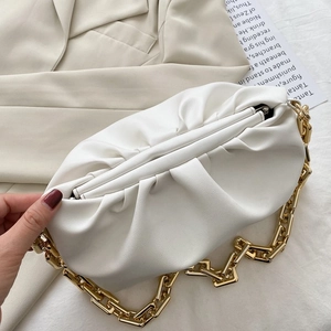 Close-up of white soft leather cloud clutch bag with chunky gold chain strap and pleats