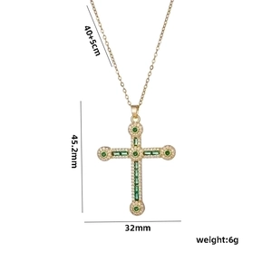 Gold hip hop cross necklace with green crystals and dimension markings on white background