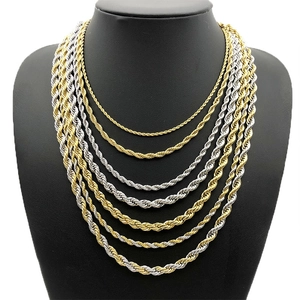 Layered gold and silver stainless steel rope chains in various lengths on a black bust