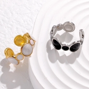 Detail of minimalist open stainless steel rings with enamel inlay on ripple texture base