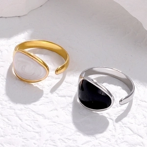 Detail of adjustable gold and silver rings with marble drop texture on white stone