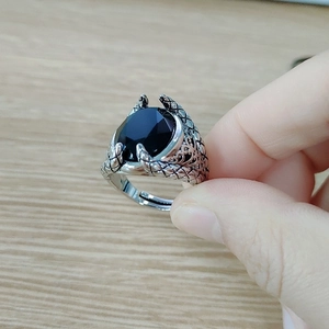 Detailed close-up of a men's punk dragon claw ring with a black oval gemstone inlay