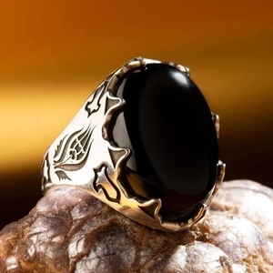 Punk style men's silver ring with large black oval gemstone and tribal carvings