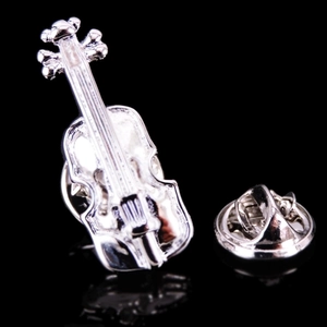 Macro detail of silver violin musical brooch with intricate strings and butterfly clasp back