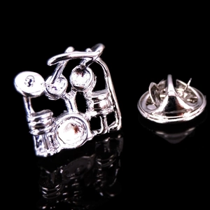 Detailed view of a silver drum kit brooch pin with a butterfly clutch back closure
