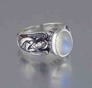 Macro shot of oval moonstone ring featuring vintage angel relief carving on silver band