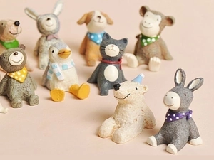 Close-up of 9 miniature resin animals like bears and penguins with colorful scarves