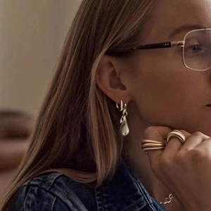 Silver teardrop earrings and stacked rings shown on model for a chic metallic look