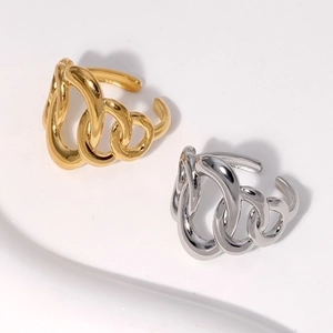 Detail of irregular geometric twisted rings in polished gold and silver stainless steel