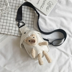 Détail d'un sac de poitrine en toile blanche avec un adorable ours en peluche