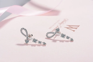 Macro detail of 925 silver ribbon earrings with heart zircons and wedding jewelry box