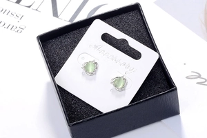 Detail of light green cat eye flower earrings with cubic zirconia in a black gift box