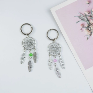 Detailed view of silver dreamcatcher keychains with green and purple beads and metal feathers