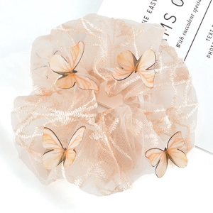 Detail of cream lace mesh scrunchie featuring 3D butterfly embroidery and soft texture