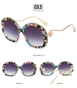 Detail of floral frame sunglasses with golden wavy temples and pearl accents
