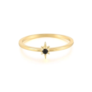 Macro shot of gold ring with black round gemstone in a celestial starburst setting