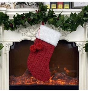 Détail de la chaussette de Noël en tricot rouge avec bordure blanche et pompons