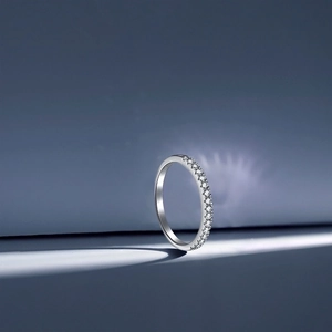 Macro detail of S925 sterling silver ring with pavé cubic zirconia on blue background