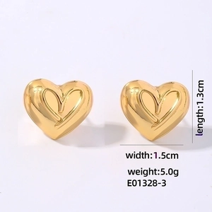 Detailed view of gold heart stud earrings showing 1.3cm by 1.5cm product dimensions