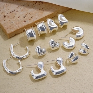 Polished silver geometric earrings collection including heart studs and hoop designs