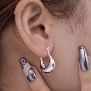 Polished silver hollow U-shaped geometric earrings worn by a model in a close-up shot