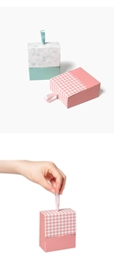 Detailed view of mini pink and teal drawer gift boxes with elegant ribbon pull handles