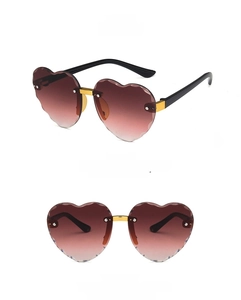 Close-up of rimless heart-shaped sunglasses with gradient brown lenses and scalloped edges