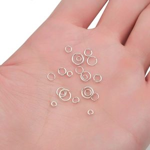 Various sizes of 925 sterling silver open jump rings held in hand for jewelry DIY