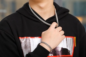 Male model wearing 8mm silver stainless steel Cuban link necklace and bracelet set
