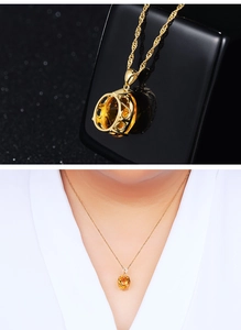 Detail of 18K gold necklace featuring a citrine pendant and heart-shaped hollow craft