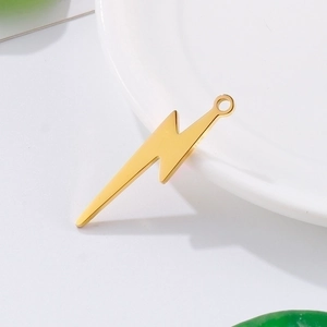 Golden lightning bolt pendant in stainless steel for DIY jewelry making on white tray