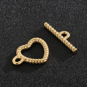 Macro shot of gold-plated twisted rope toggle clasp with heart ring and bar for DIY jewelry