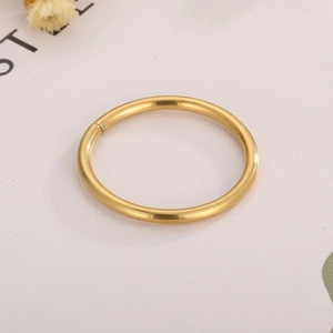 Close-up of a large golden stainless steel open jump ring for DIY jewelry making