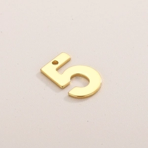 Macro shot of gold-plated stainless steel number 5 pendant for DIY jewelry making