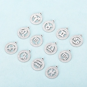 Set of 12 hollowed silver zodiac charms with sparkling crystal insets on blue surface