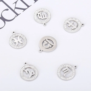 Macro shot of gold-plated zodiac pendants with rhinestone borders and cutout symbols