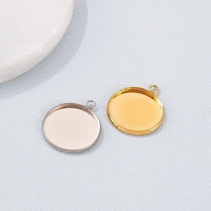 Polished silver and gold round stainless steel pendant trays on marble background