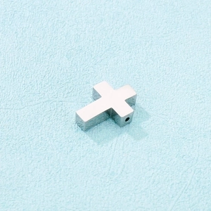 Close-up of polished stainless steel cross pendant with side hole for DIY jewelry making