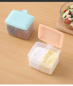 Close-up of double-grid kitchen seasoning box with peach lid, salt and small spoon detail