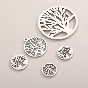 Polished silver stainless steel Tree of Life pendants in various sizes on beige background