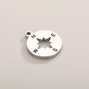 Macro view of silver star compass pendant featuring N E S W direction engravings