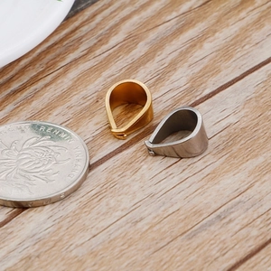 DIY jewelry pinch bails in gold and silver steel shown with a coin for size comparison